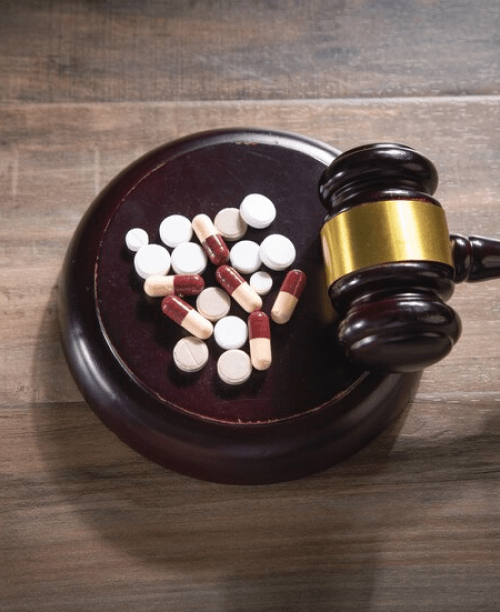 judge gavel with pills-wooden table